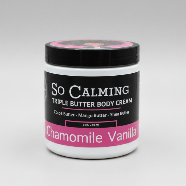 A jar of So Calming Triple Butter Body Cream in Chamomile Vanilla scent, featuring a black label with white text and pink accents, and a matching pink lid.